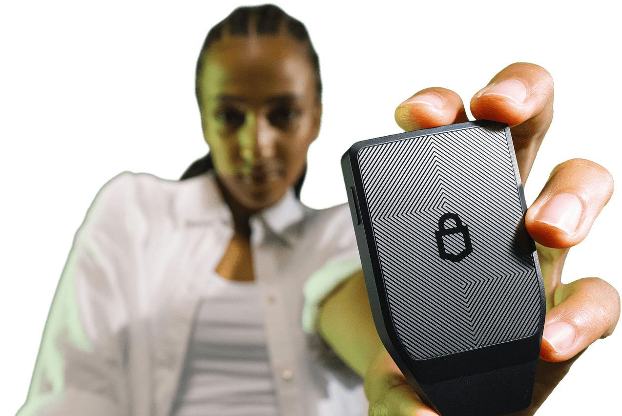 Woman holding a Trezor Safe 7 toward the camera