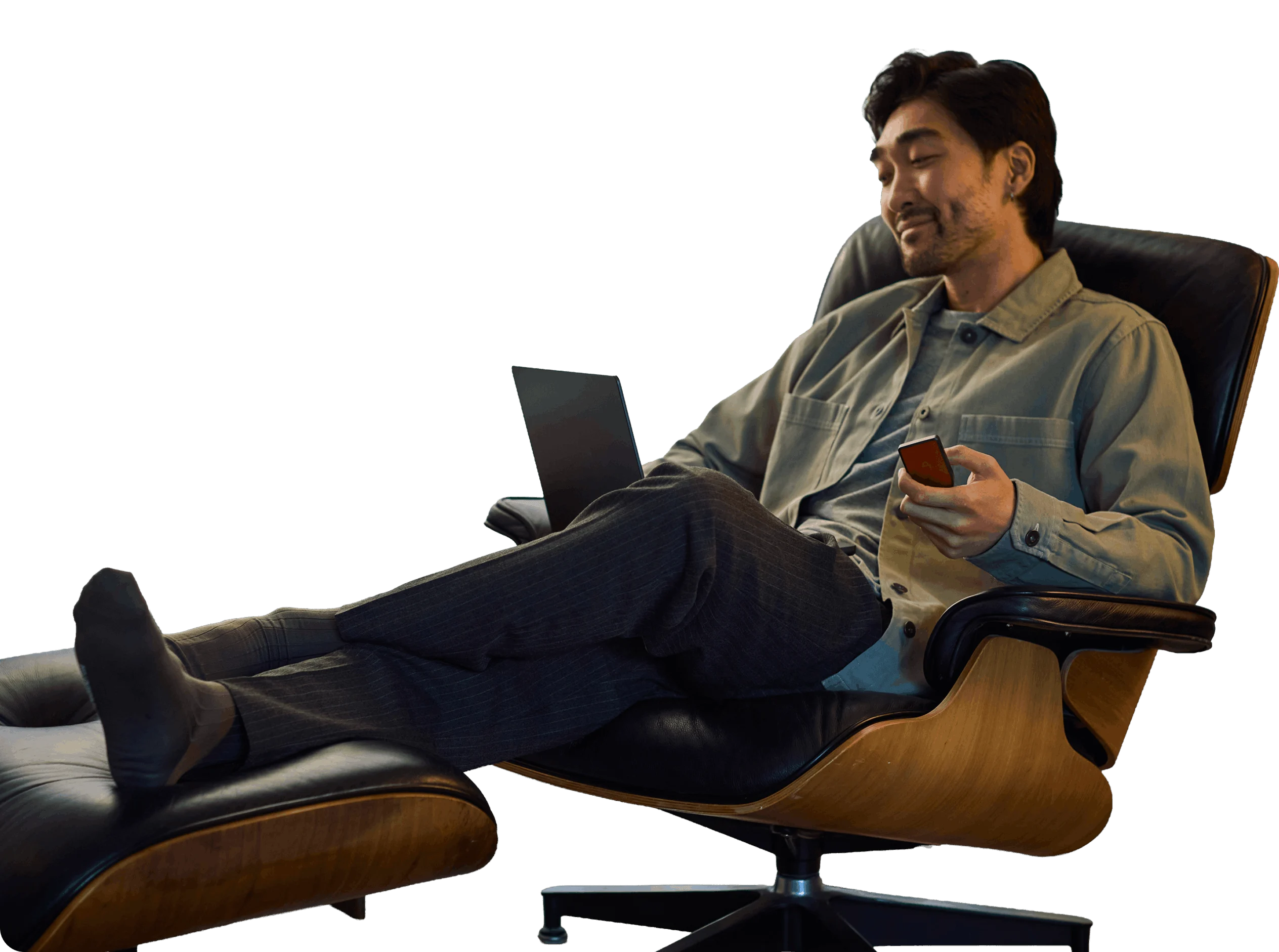 Man relaxing in a chair with a laptop and a Trezor Safe 7 in his hand